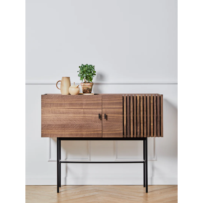 The small Array Sideboard from Woud in walnut with accessories on top.