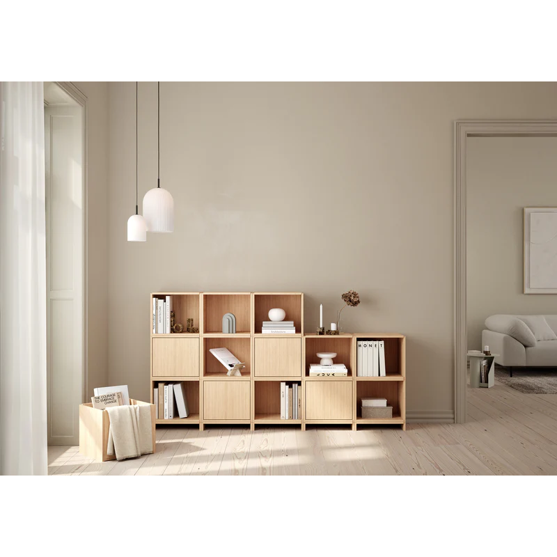 The Bricks Cube from Woud in white pigmented oak being used in a living room to display books, decor, or even as a storage box.