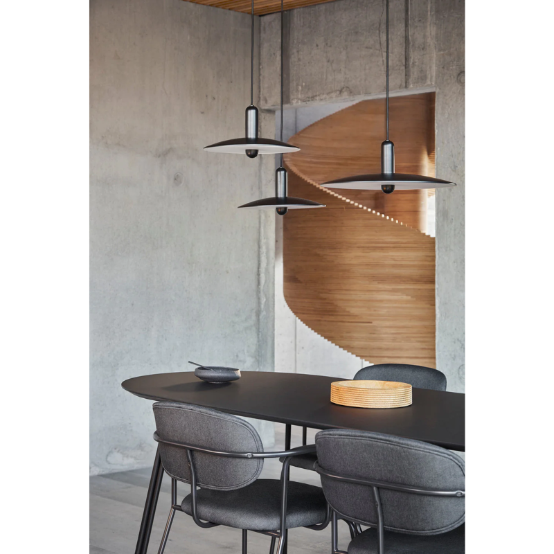 The Frame Dining Chair from Woud tucked into a dining table.