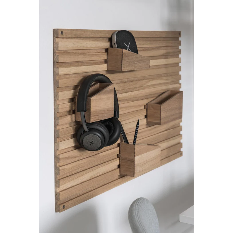 The Input Organizer from Woud by used to hold headphones, a portable speaker and some pencils.