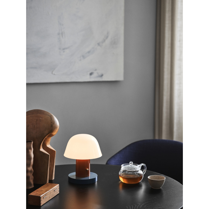 The Setago Portable Lamp from &Tradition on a dining table.