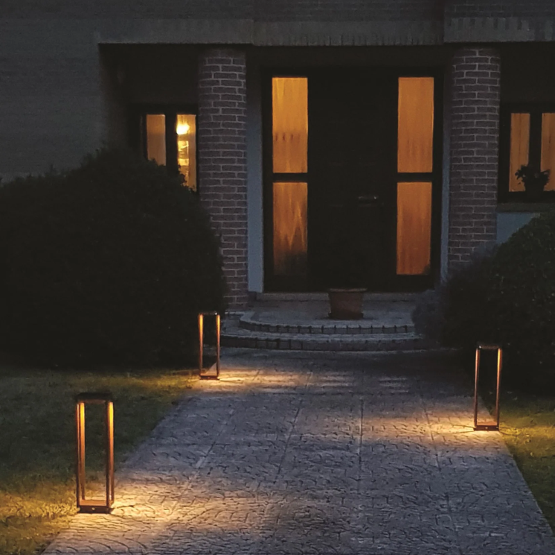 The rust Home Solar from Zafferano outdoors illuminating a pathway.
