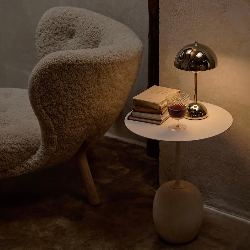 &Tradition VP9 Flowerpot Portable Table Lamp in brass plated in a living room on a side table.