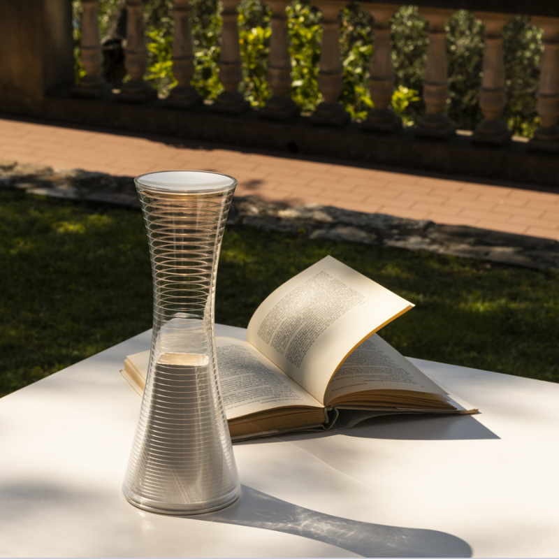 The Come Together Portable Lamp from Artemide in white in an outdoor living area.