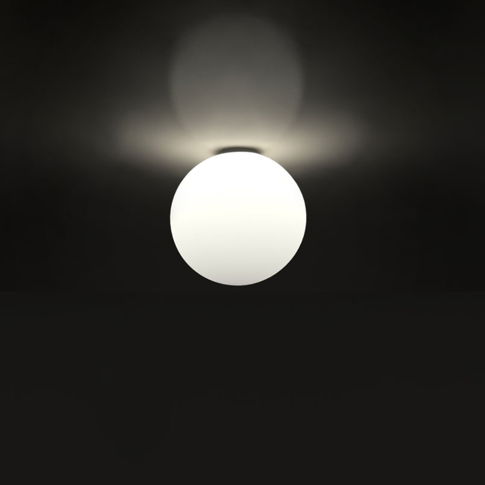 The Dioscuri Wall / Ceiling Light from Artemide in the size medium turned on installed on the ceiling.