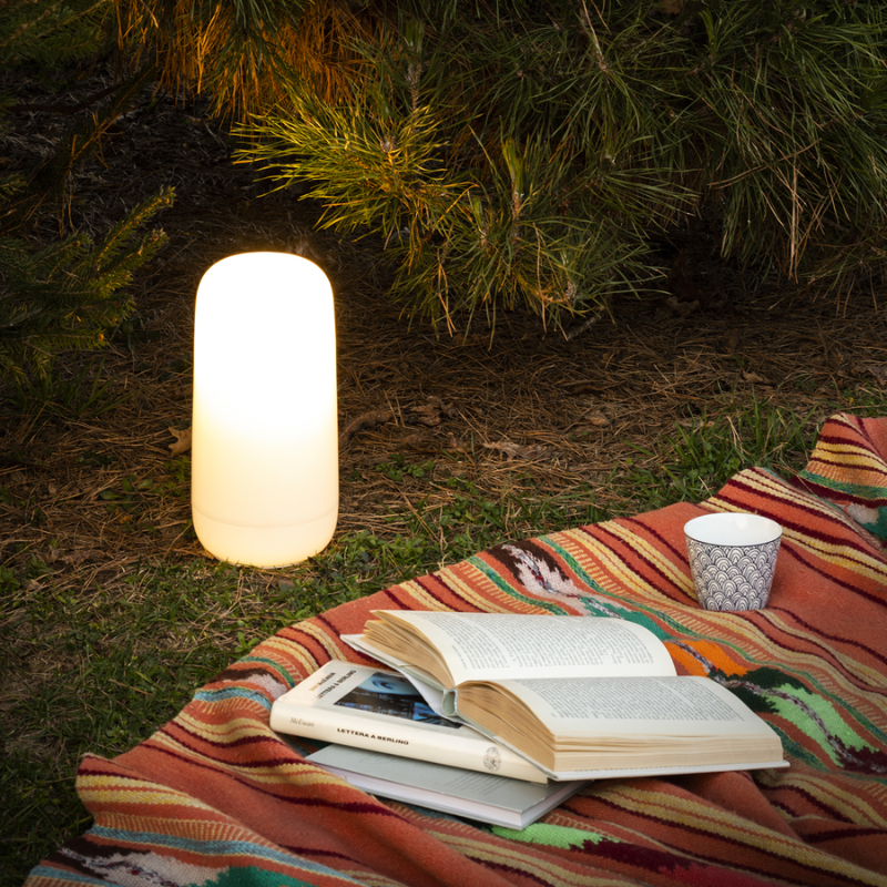 The Gople Portable Lamp from Artemide in a garden.
