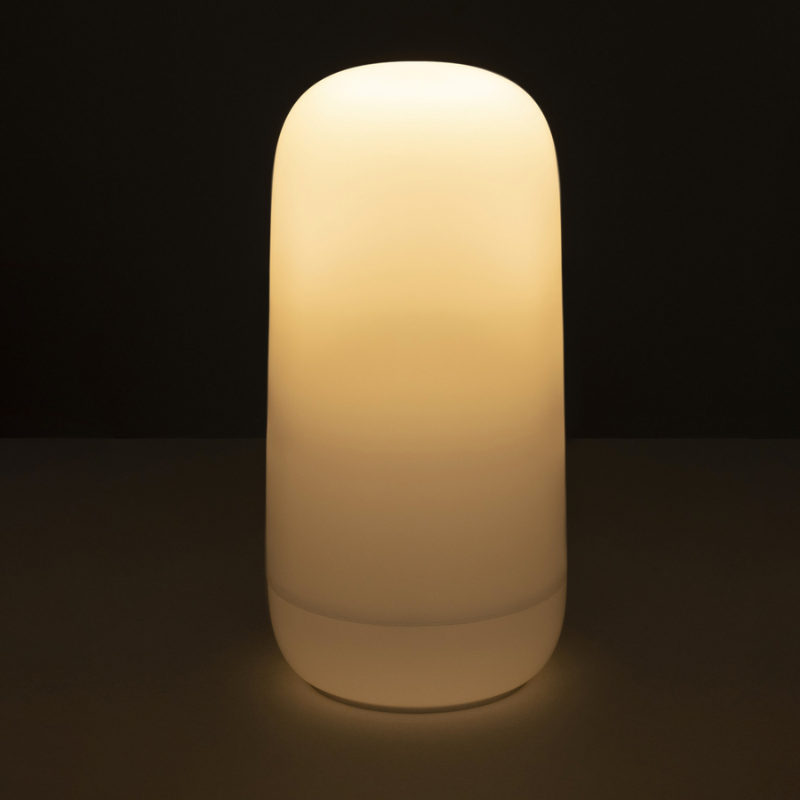 The Gople Portable Lamp from Artemide turned on in a dark room.