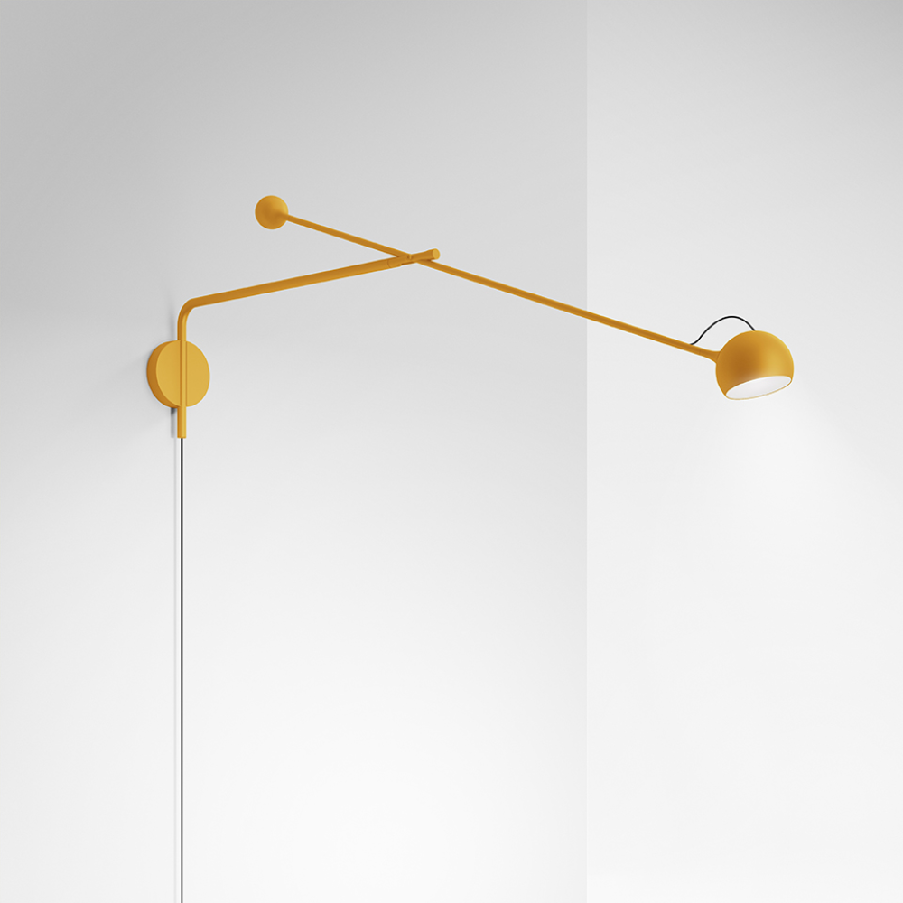 The yellow Ixa Arm Plug In Wall Sconce from Artemide in a commercial space.