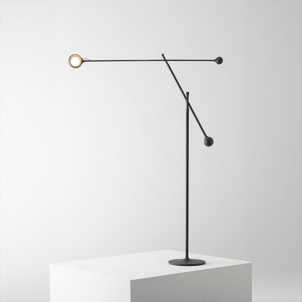 The anthracite gray Ixa Classic Floor Lamp from Artemide in a living space.