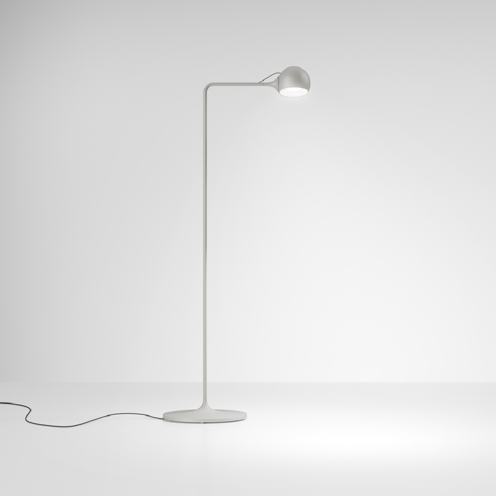 The white Ixa Reading Floor Lamp from Artemide in a living area.