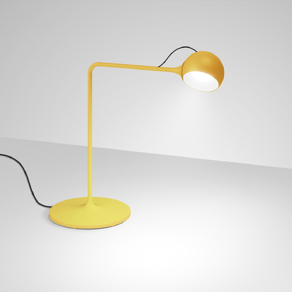 The yellow Ixa Table Lamp from Artemide in a living area.