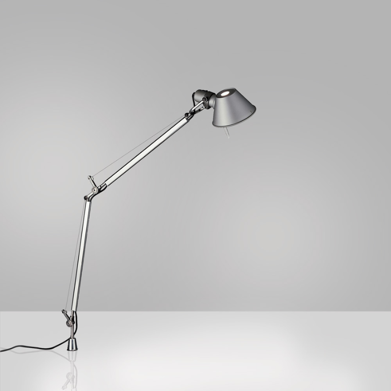 The Tolomeo Midi Table Lamp from Artemide in aluminum with the in-set pivot in a studio.