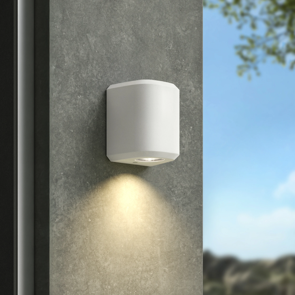 The Brixham Wall Single outdoor sconce in white concrete by Astro Lighting installed outside during the day.