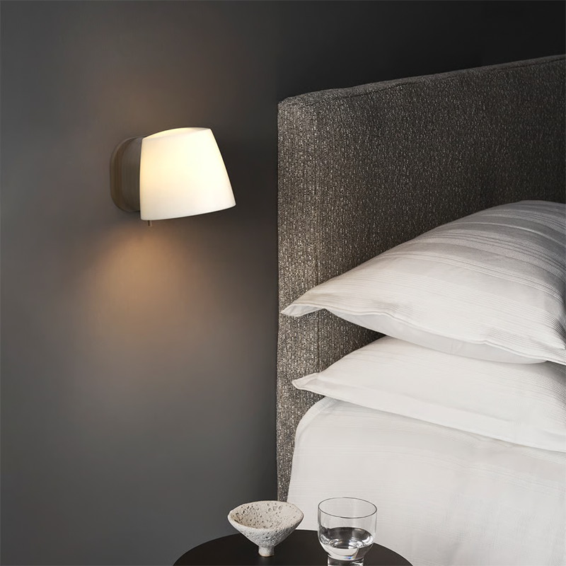 The Imari Wall Lamp from Astro Lighting in bronze in a primary bedroom.