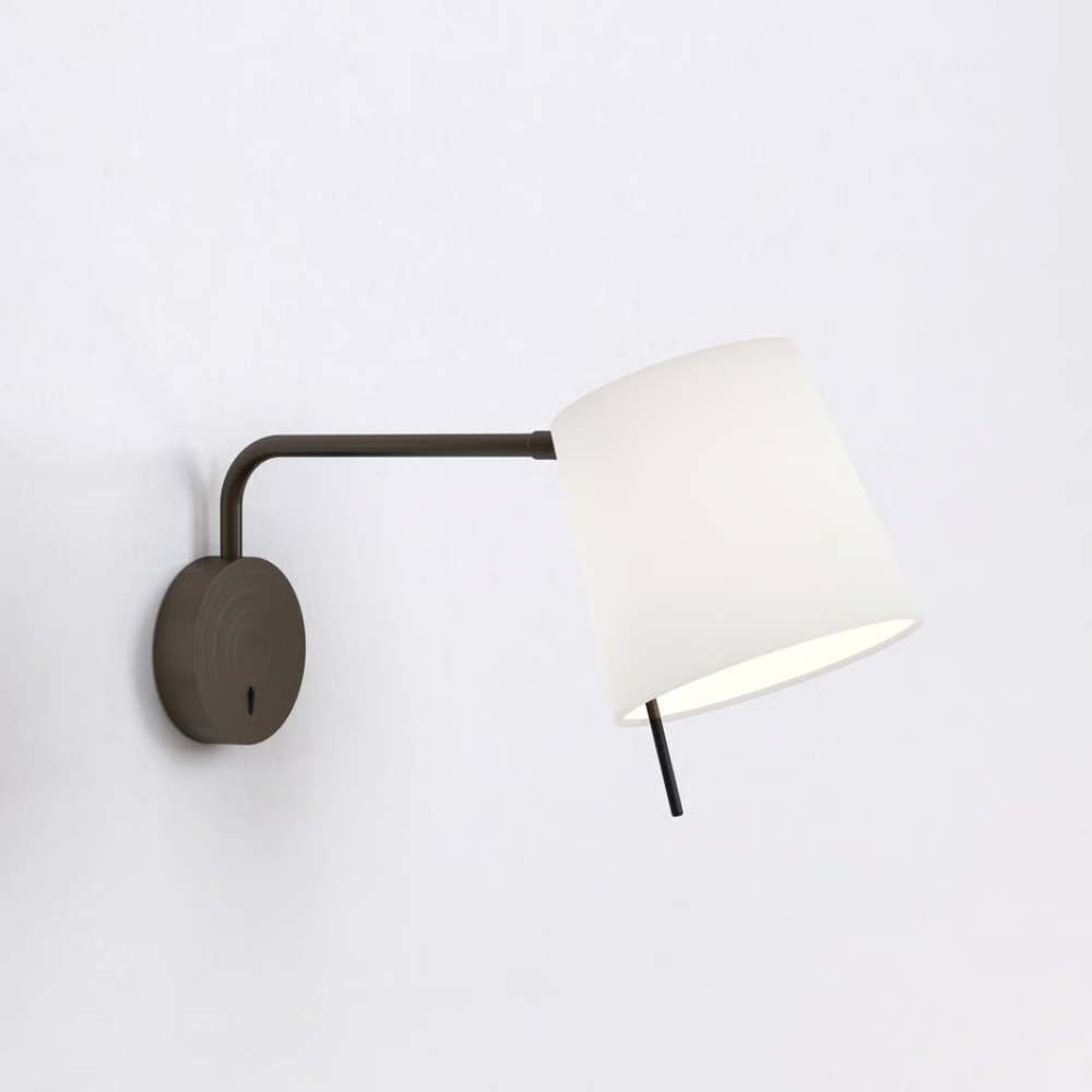 The bronze Mitsu Swing Arm Wall Sconce from Astro Lighting with the white shade in a living space.