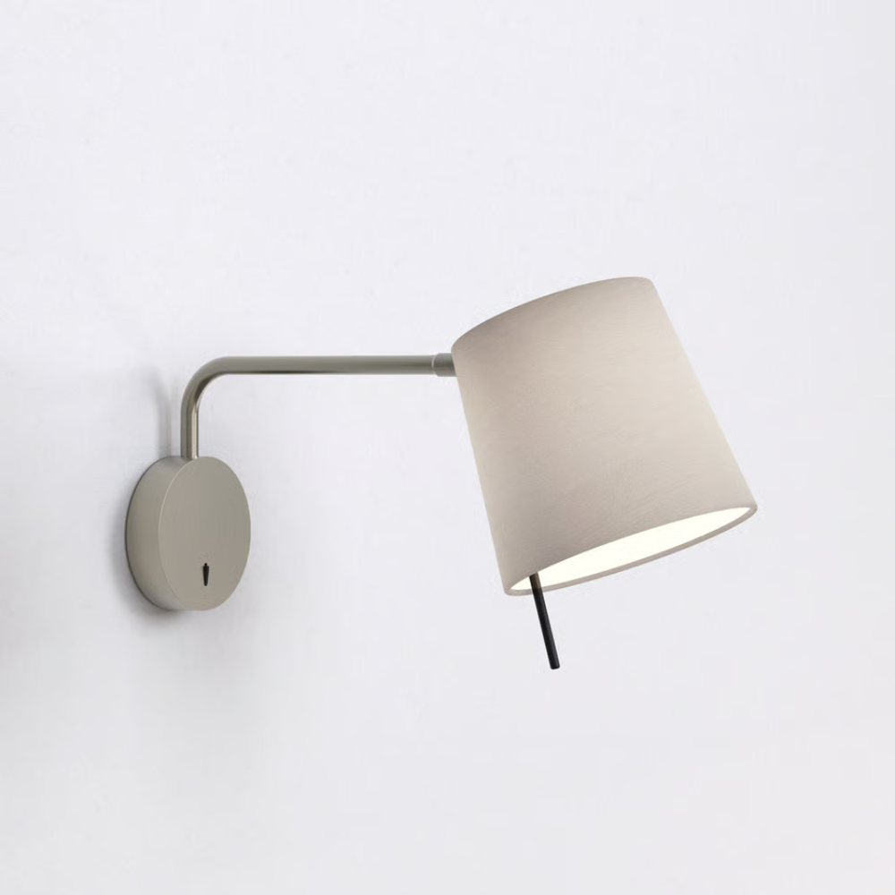 The matte nickel Mitsu Swing Arm Wall Sconce from Astro Lighting with the putty shade in a hotel room.