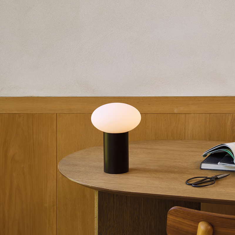 The Zeppo Portable Lamp from Astro Lighting in matt black in a workspace.