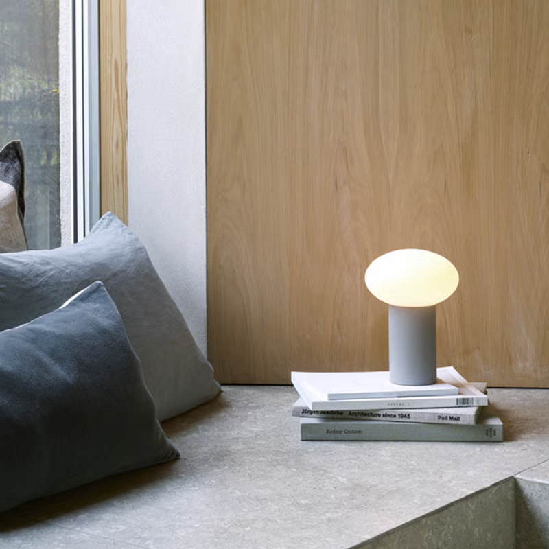 The Zeppo Portable Lamp from Astro Lighting in pebble grey in a living room.