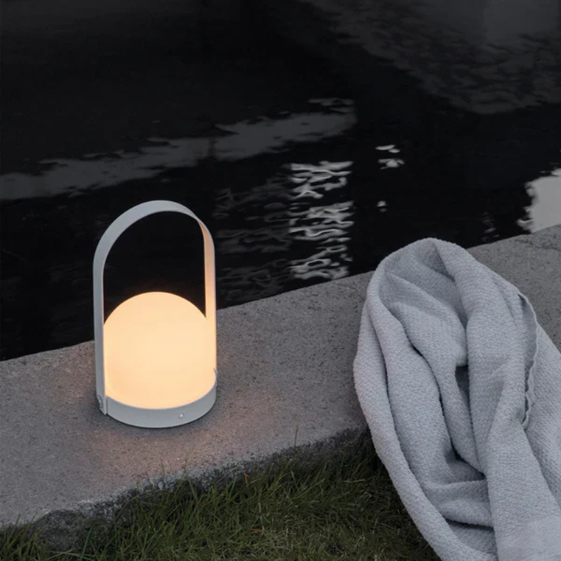 The Carrie Portable LED Lamp from Audo Copenhagen poolside.
