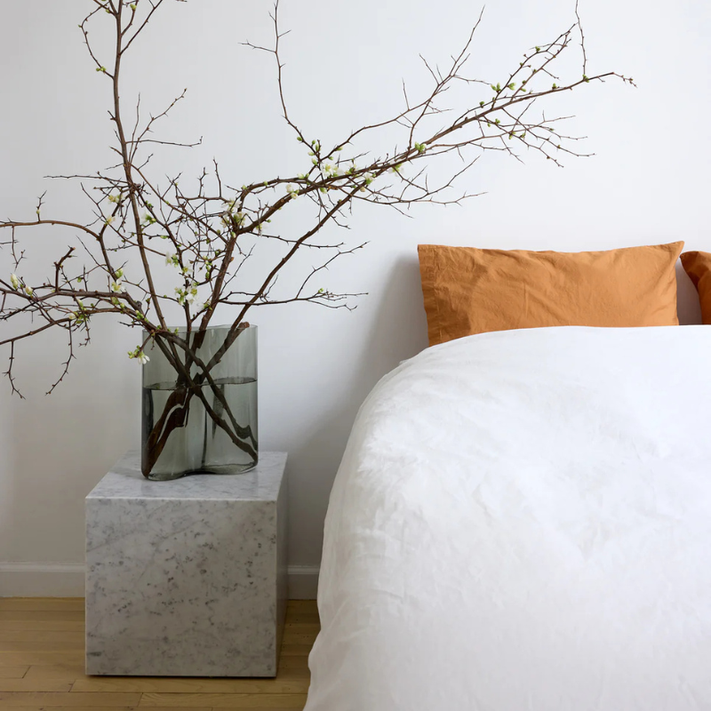 The Cubic Marble Plinth from Audo Copenhagen in a bedroom.