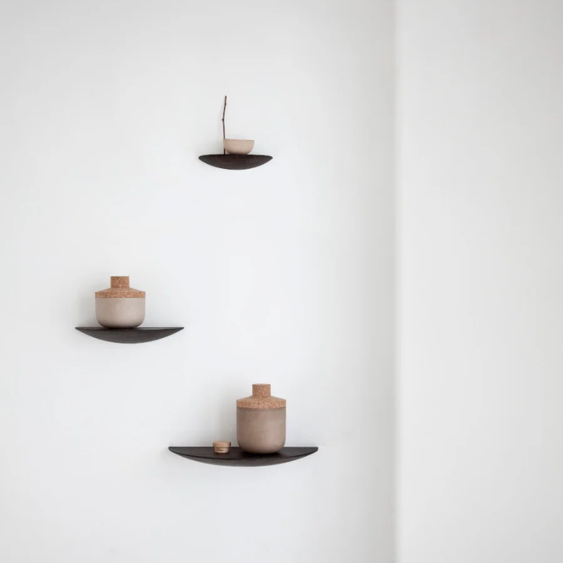 The Gridy Fungi Shelf from Audo Copenhagen in black oak on the wall of the living room.