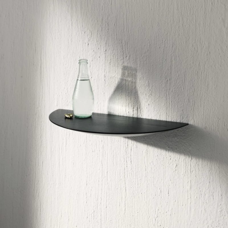 The Gridy Fungi Shelf from Audo Copenhagen in black oak in a large size is in the living room.