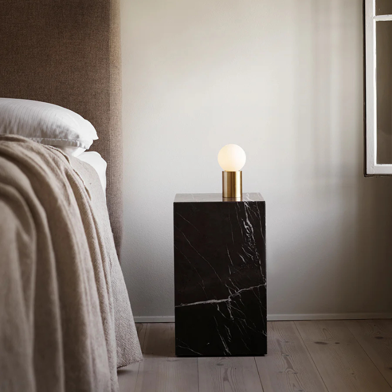 The Tall Marble Plinth from Audo Copenhagen in a bedroom.