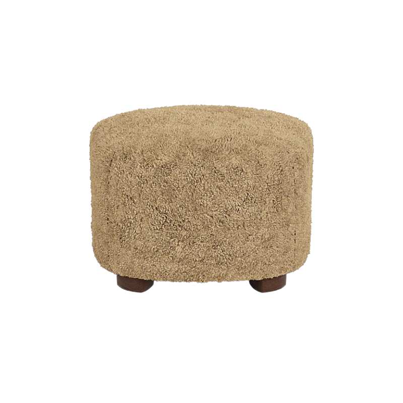 The Tired Man Sheepskin Ottoman from Audo Copenhagen in honey with dark stained oak legs from the back.