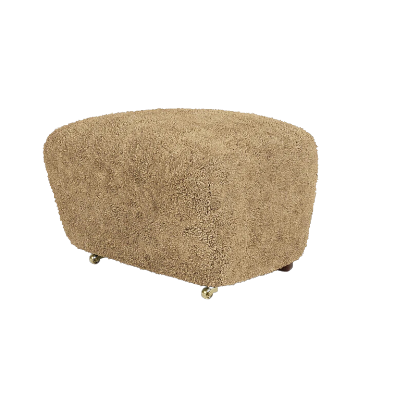 The Tired Man Sheepskin Ottoman from Audo Copenhagen in honey with dark stained oak legs corner.