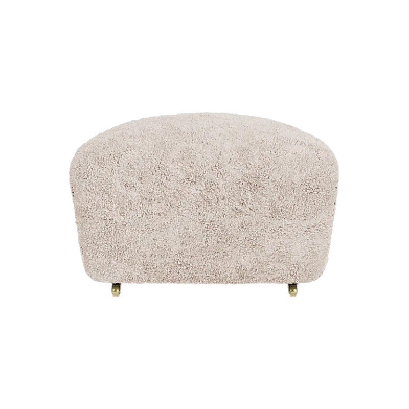 The Tired Man Sheepskin Ottoman from Audo Copenhagen in moonlight with dark stained oak legs from the front.