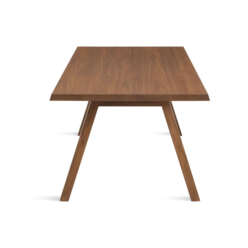 The 72 inch A Walk in the Park Dining Table from Blu Dot in walnut from the side at an angle.