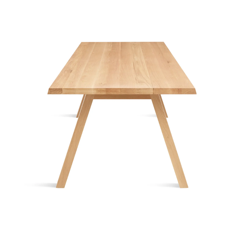 The 90 inch A Walk in the Park Dining Table from Blu Dot in white oak from the side at an angle.