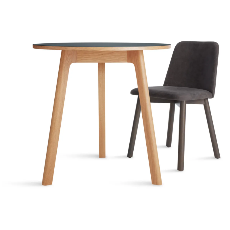 The 30 inch Apt Café Table from Blu Dot with navy green table top and white oak body in a studio.