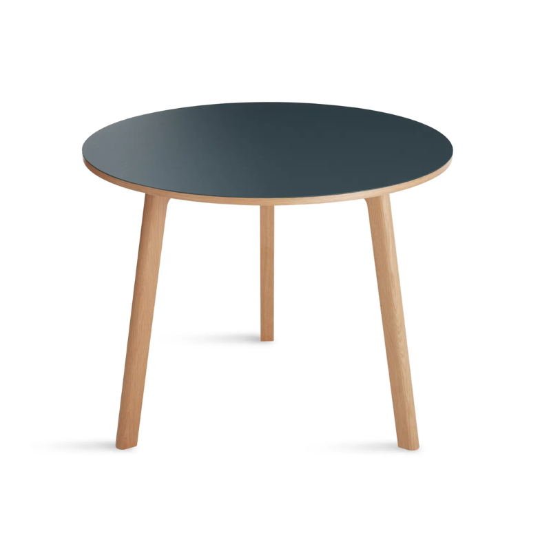 The 36 inch Apt Café Table from Blu Dot with navy green table top and white oak body from an angle.