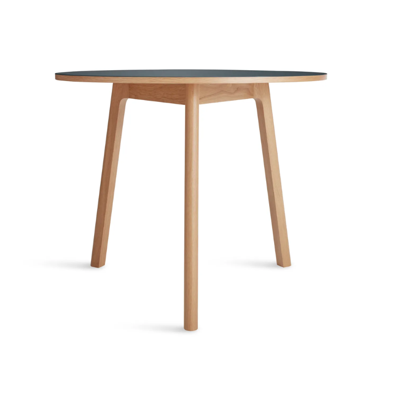 The 36 inch Apt Café Table from Blu Dot with navy green table top and white oak body from the side.