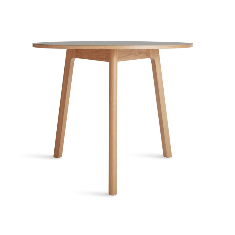 The 36 inch Apt Café Table from Blu Dot with putty table top and white oak body from the side.
