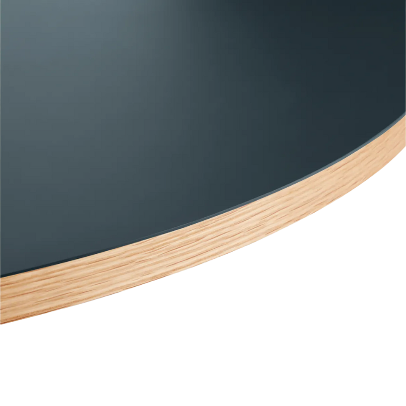 The Apt Café Table from Blu Dot with navy green table top and white oak body close up.