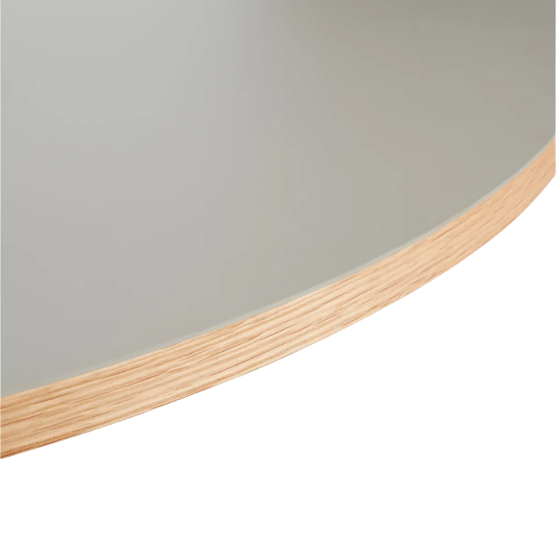 The Apt Café Table from Blu Dot with putty table top and white oak body close up.