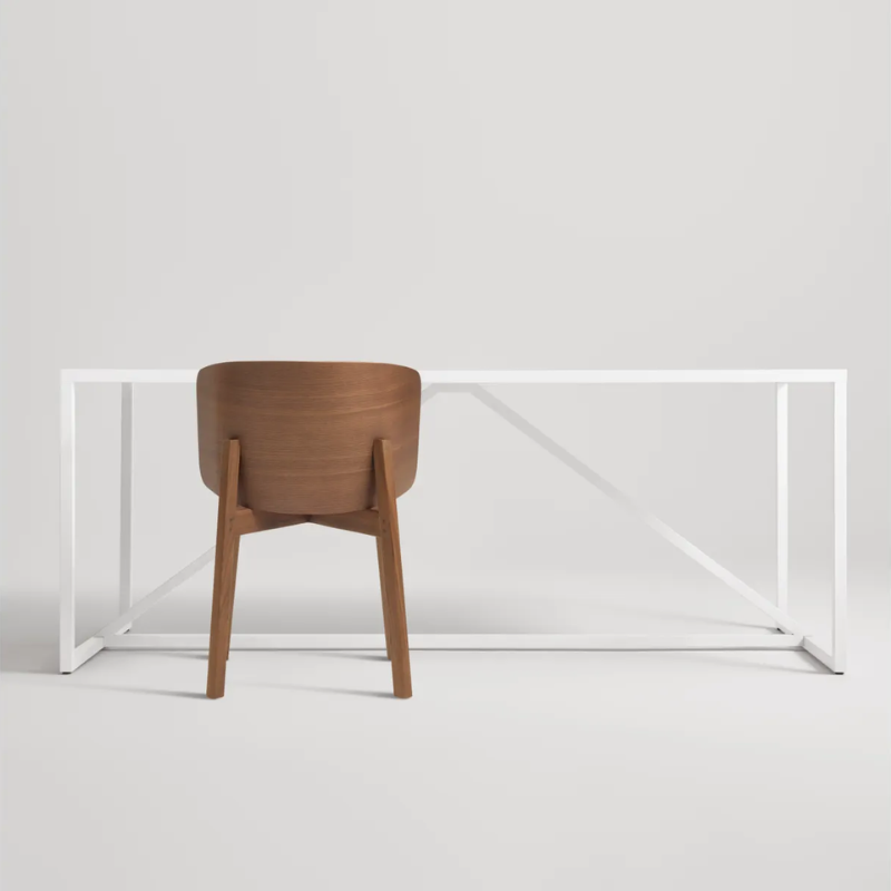 The Buddy Chair from Blu Dot in walnut in a studio.