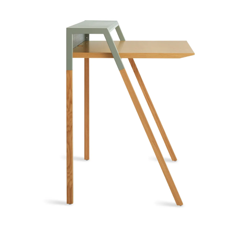 The Cant Desk from Blu Dot with white oak body and grey green back from an angle.