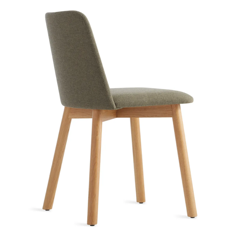 The Chip Chair from Blu Dot with white oak legs and toohey olive upholstery from the back at an angle.
