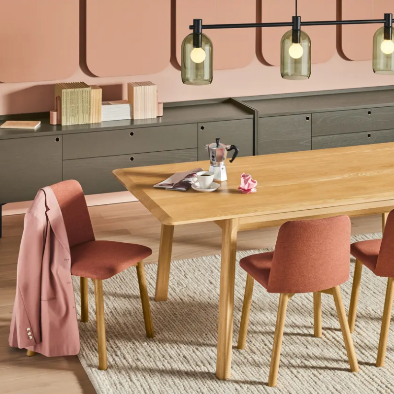 The Chip Chair from Blu Dot with white oak legs and toohey tomato upholstery in a dining room.