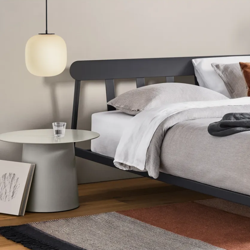 The Circula Low Side Table from Blu Dot in putty in a bedroom.