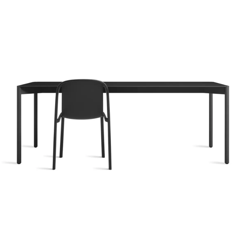 The Comeuppance Dining Table from Blu Dot in oblivion in a living room.