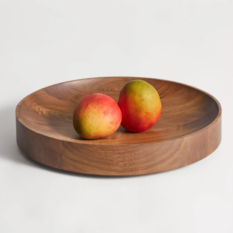 The Cusp Medium Bowl from Blu Dot in walnut in a family room.