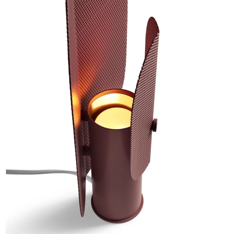 The Filter Table Lamp from Blu Dot in oxblood focusing on the light bulb turned on.