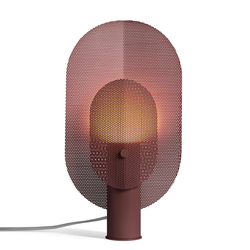 The Filter Table Lamp from Blu Dot in oxblood turned on.