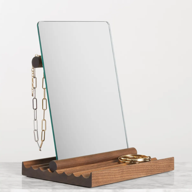 The Furrow Table Mirror from Blu Dot in walnut in a primary bedroom.