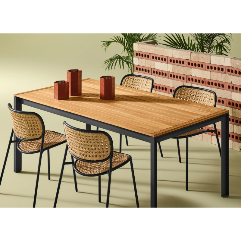 The Hold Tight 76" Outdoor Dining Table from Blu Dot in carbon and teak in a family room.