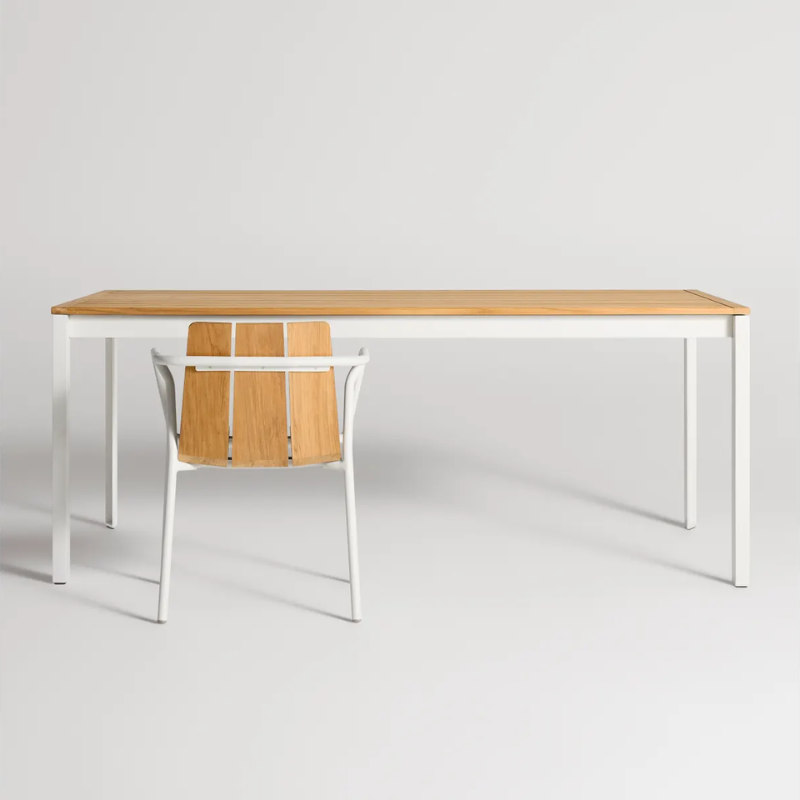 The Hold Tight 76" Outdoor Dining Table from Blu Dot in white and teak in a studio.